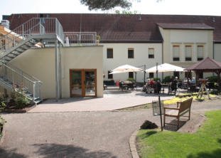 Sonnige Terrasse mit Sonnenschirmen und Sitzgelegenheiten im Innenhof